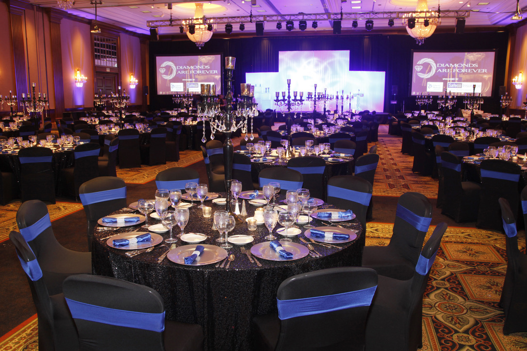 Living Energy gala event with banquet tables, stage lighting, and projection screens